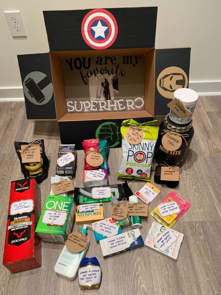 an open box filled with lots of different types of food and condiments on top of a wooden floor