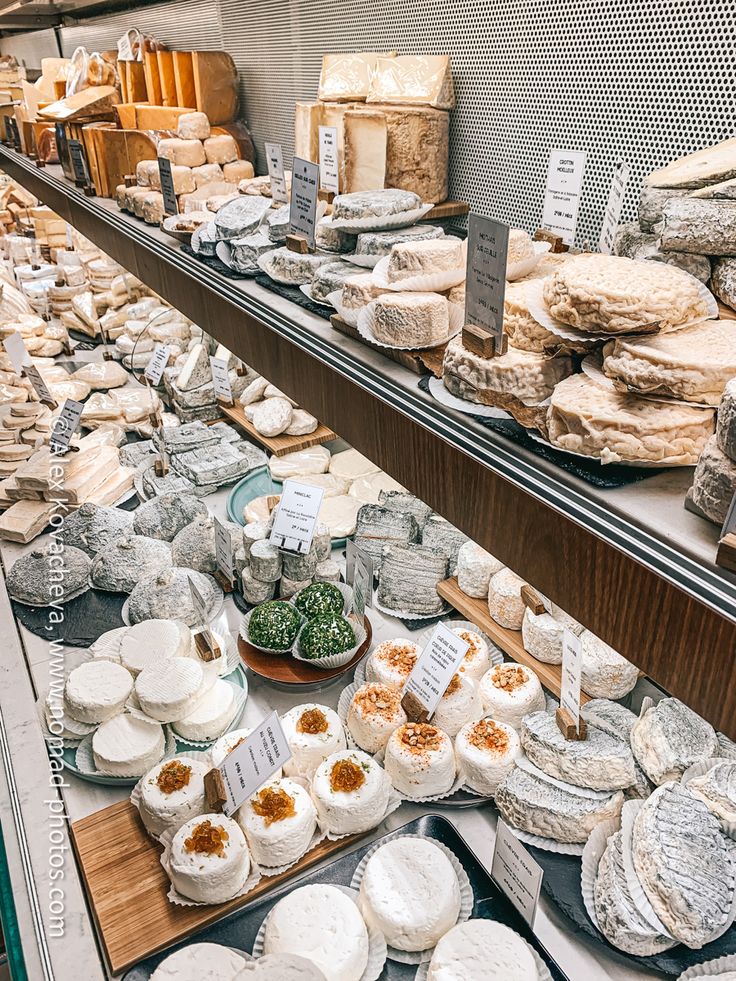 an assortment of cheeses on display in a store