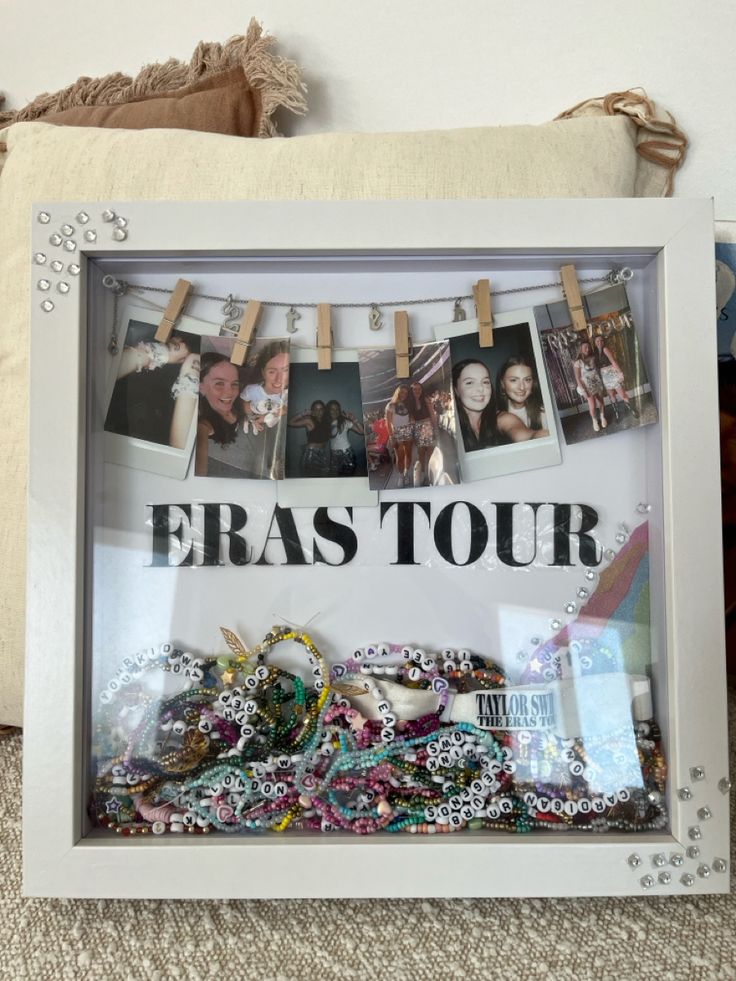 a white frame with some pictures hanging from it's sides and the words eras tour