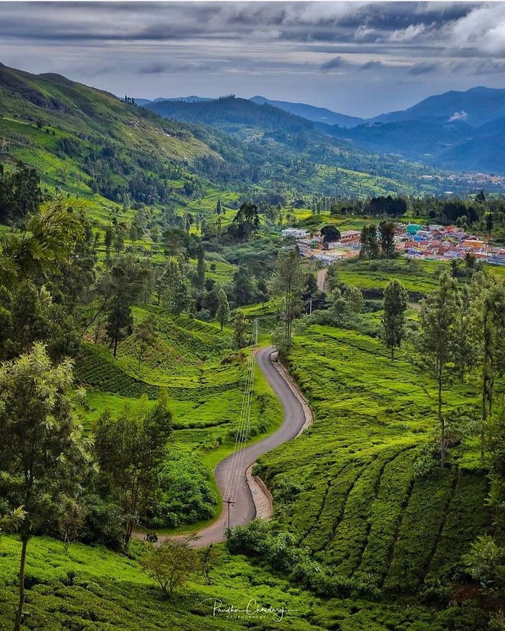 a winding road in the middle of a lush green valley