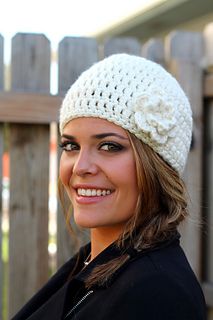 a smiling woman wearing a white crocheted hat