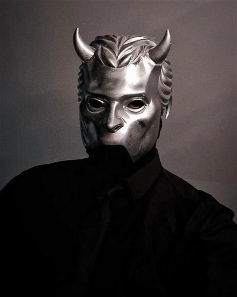 a man wearing a mask with horns on his head