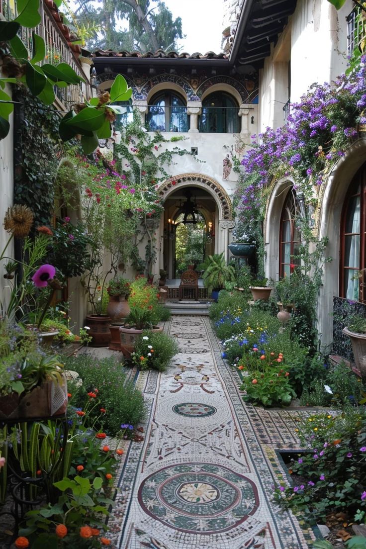 an outdoor courtyard with lots of plants and flowers on the walkway, surrounded by potted plants