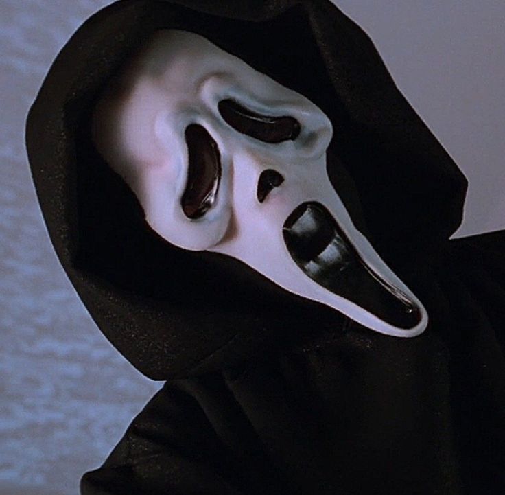 a person wearing a white mask and black hood