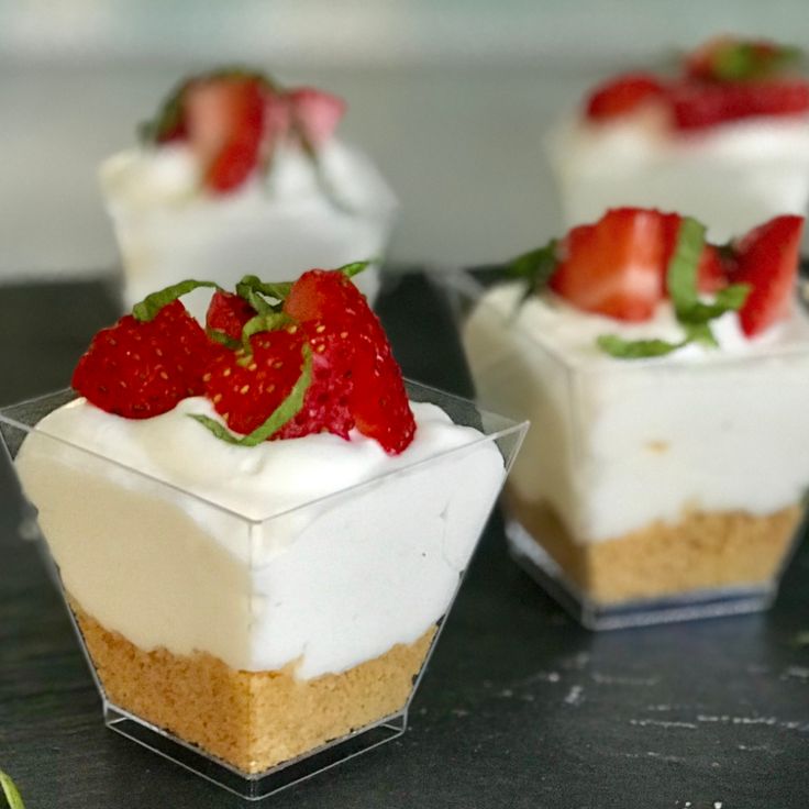 three small desserts with strawberries on top