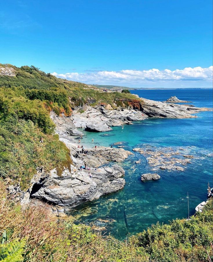 the water is crystal blue and clear with rocks on it's sides, while people are