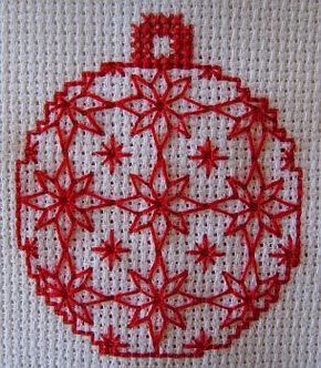 a red ornament on a white piece of cloth is shown in the shape of a christmas ball