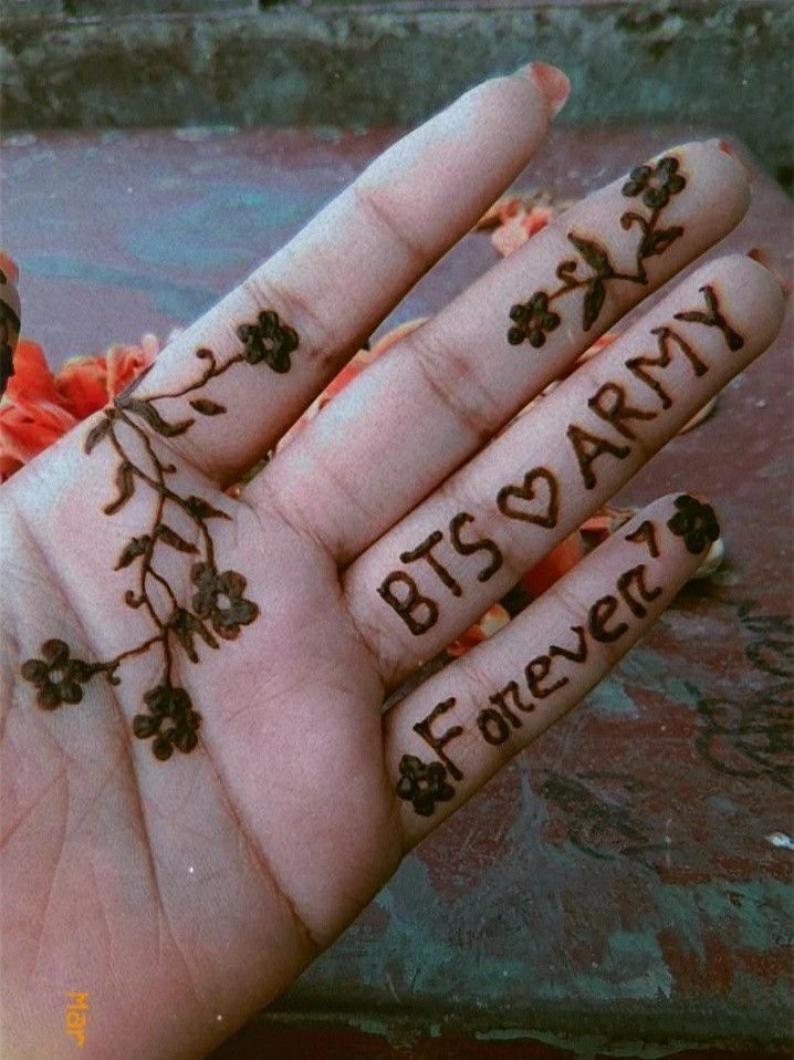 a person's hand with two fingers decorated with flowers and the words bits & army written on it