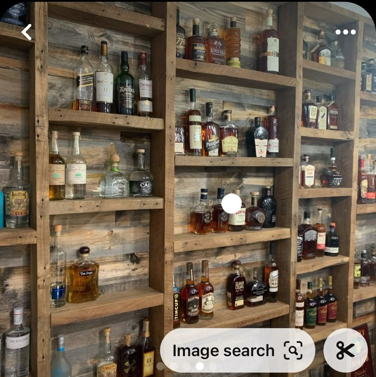 a wooden shelf filled with lots of different types of liquor bottles on it's sides