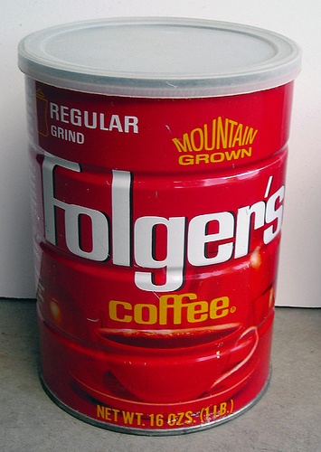 a can of coffee sitting on top of a counter next to a white wall and floor