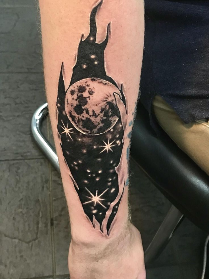 a person with a tattoo on their leg that has the moon and stars in it