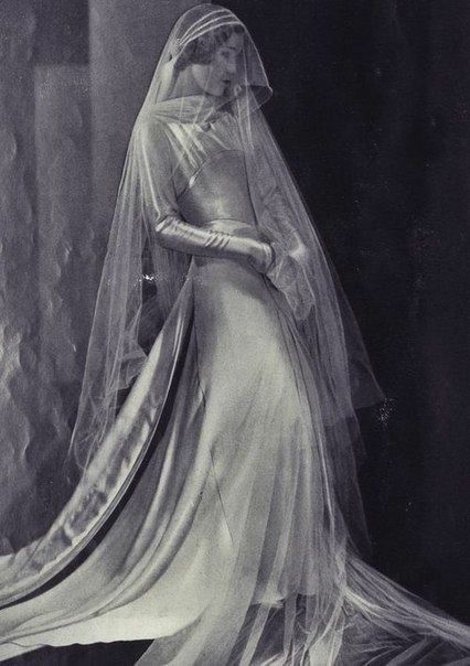 an old photo of a woman in a wedding dress with a veil on her head