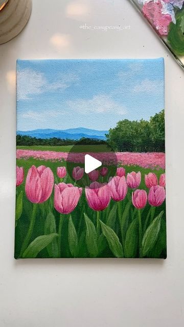 a painting of pink tulips on a white surface with a video player in the background