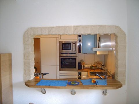 the reflection of a kitchen in a mirror is seen through a hole in the wall