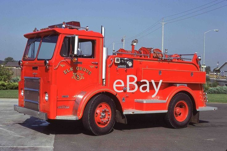 an old red fire truck parked in a parking lot with the word e bay on it's side