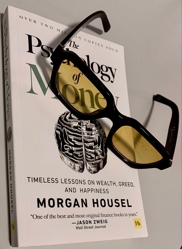 a pair of glasses sitting on top of a book titled the persoly of money