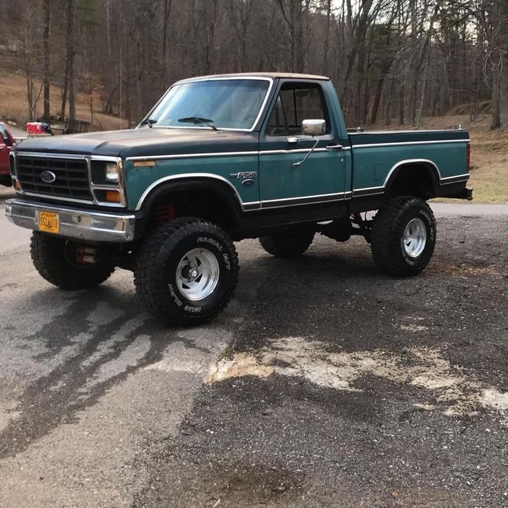 a green pick up truck parked in a parking lot