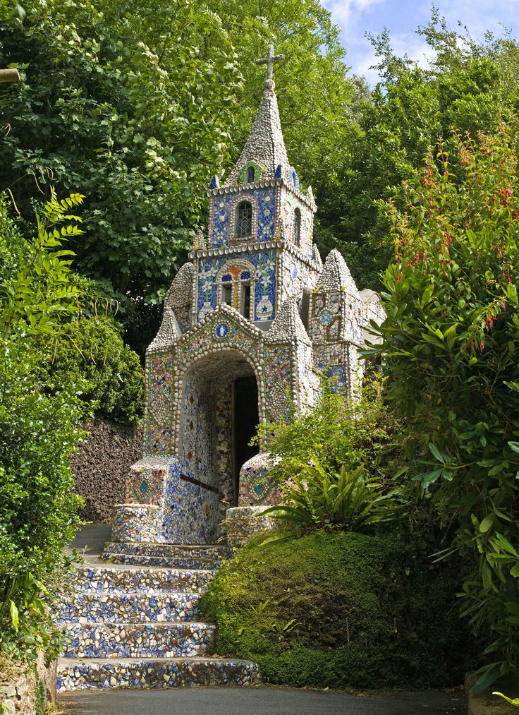 an ornate building with blue and white tiles on it's side, surrounded by greenery