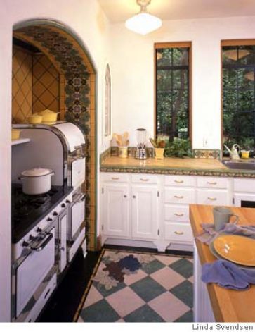 a kitchen with an oven, sink and counter tops in white cabinets next to a checkered floor