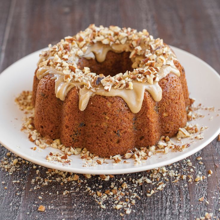 a bundt cake with frosting and nuts on a plate