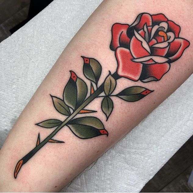 a red rose with green leaves on the left forearm and right arm, is shown