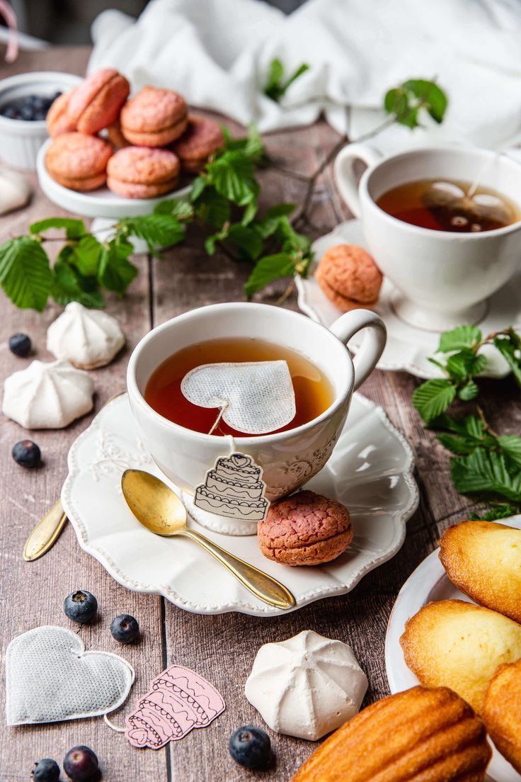 two cups of tea and some cookies on a table