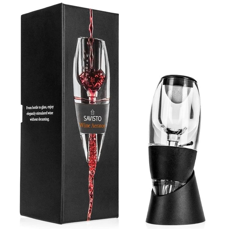 a wine glass is being filled with red wine from the bottle in front of a black box