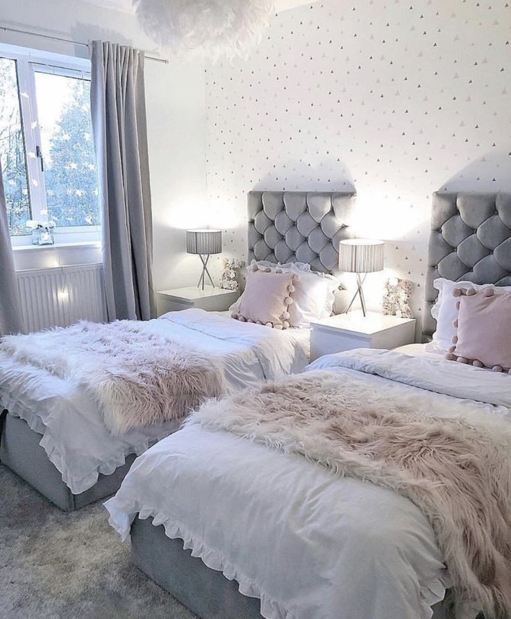 two beds with fluffy blankets and pillows in a bedroom