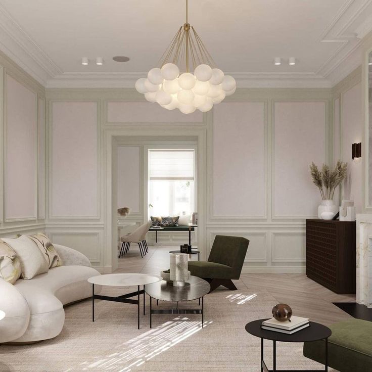 a living room filled with furniture and a chandelier hanging over the fire place