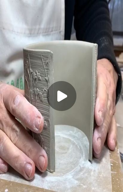 a person is making something out of clay with their hands on the edge of it