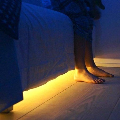 a person sitting on a bed with their feet propped up against the edge of the bed