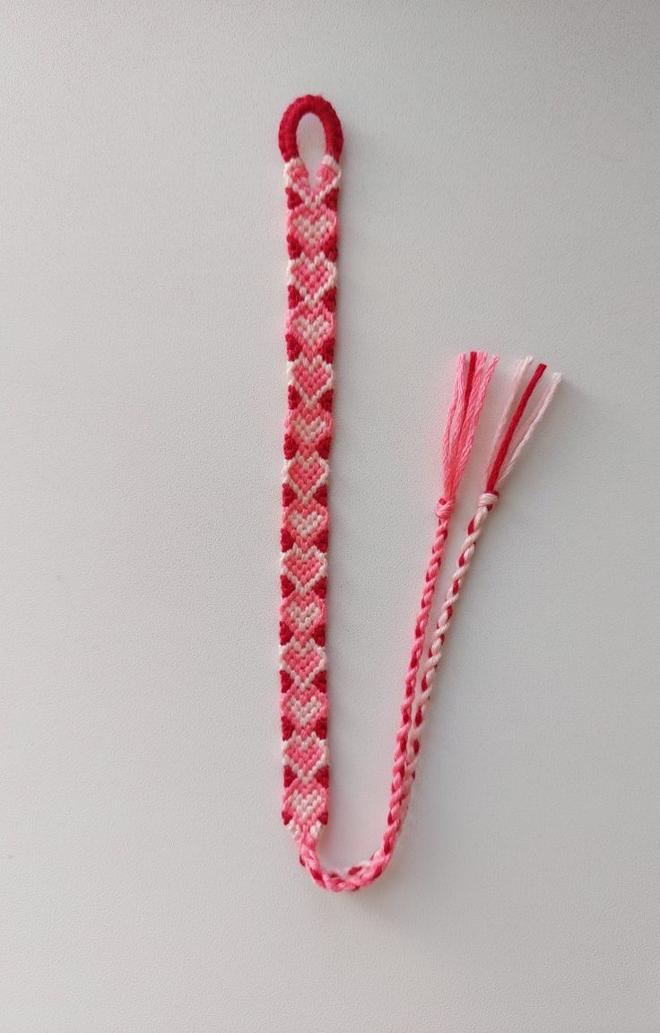 a pink and white piece of fabric with two tassels