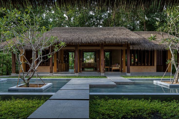 a house with a thatched roof surrounded by greenery