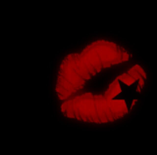 a red lipstick with a star painted on it's side in the dark,