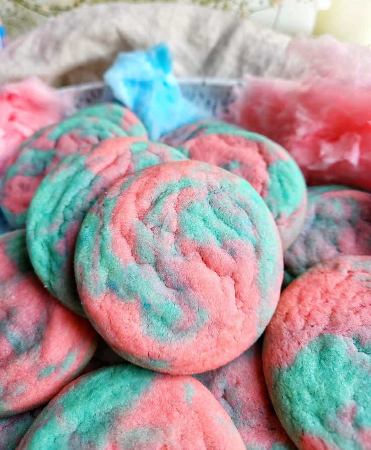 some pink and blue cookies are in a bowl