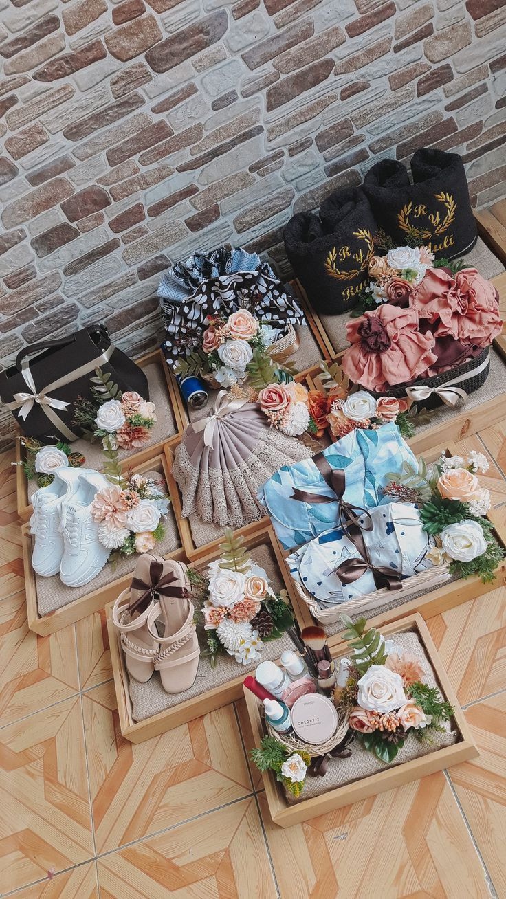 several pairs of baby shoes are arranged on the floor in front of a brick wall