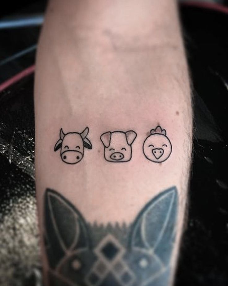 three small tattoos on the leg of a person's arm, each with an animal and pig