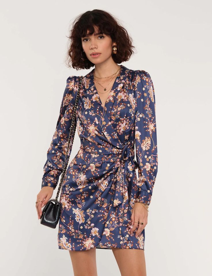 Our Maisie Dress features a wrap bodice with a flattering side tie detail to accentuate your waist. Featuring smocked cuffs and a flouncy hem, the Maisie Dress is perfect for a luxe night out. Pair with leather booties and our Rosa Jacket for an effortlessly chic look. Chic Fitted Wrap Dress With Surplice Neckline, Elegant Wrap Dress With Floral Print And Surplice Neckline, Elegant Floral Wrap Dress With Surplice Neckline, Fitted Faux Wrap Dresses For Fall, Chic Mini Wrap Dress With Tie Waist, Fall Date Night Midi Wrap Dress, Fitted Wrap Dress With Ruched Surplice Neckline, Fitted Ruched Wrap Dress With Surplice Neckline, Elegant Floral Print Wrap Dress For Date Night