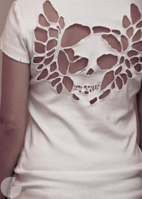 a woman wearing a white t - shirt with holes in the shape of leaves on her chest