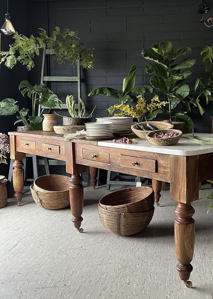 a wooden table topped with lots of potted plants