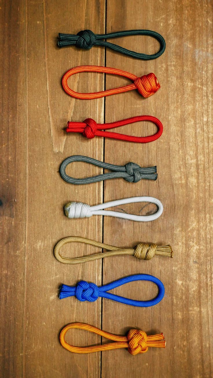 several ropes laid out on a wooden surface with one knot in the middle and another knot at the end