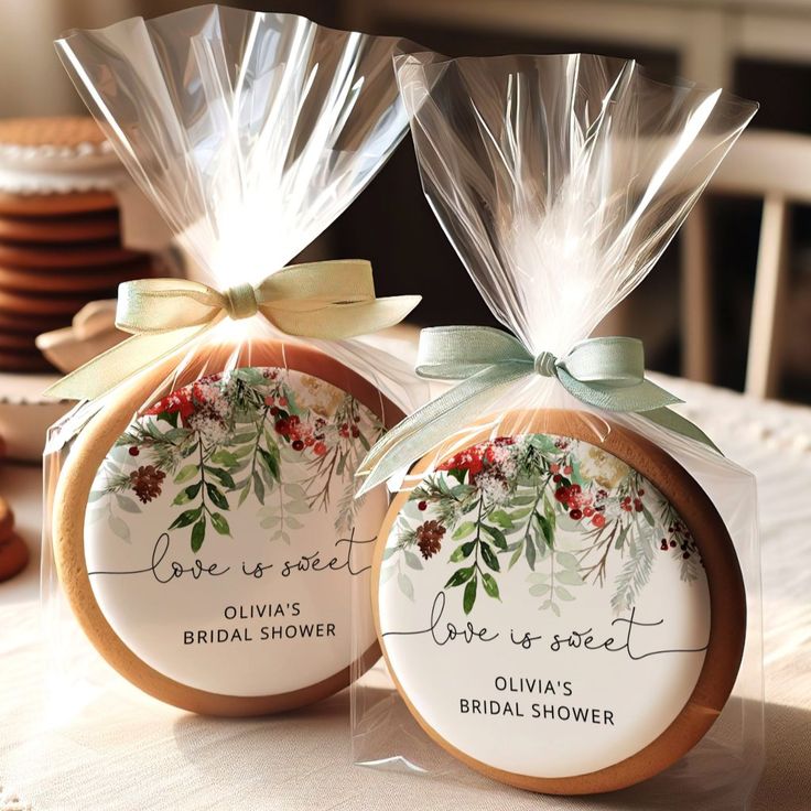 two cookies wrapped in clear cellophane and tied with bows are sitting on a table