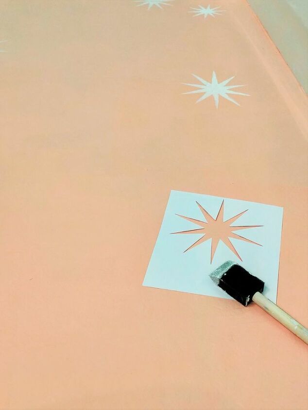 a paintbrush is sitting on top of a sheet of paper with stars drawn on it