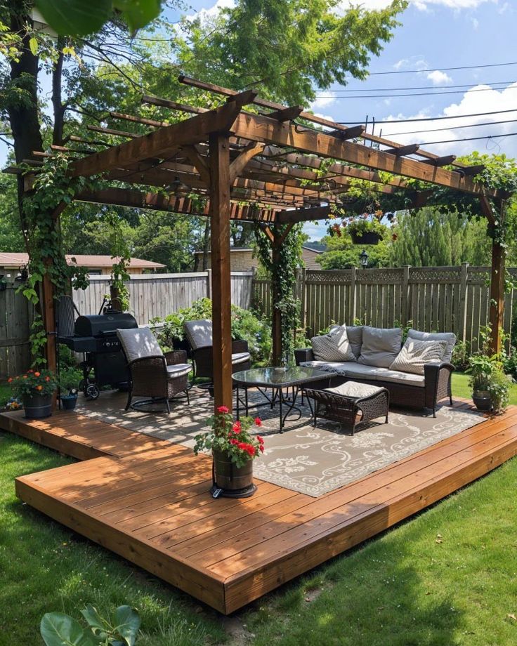 an outdoor living area with patio furniture and pergolated plants on the deck, surrounded by greenery