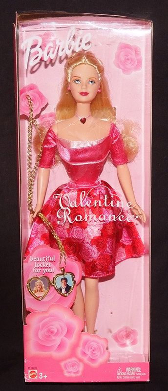 the barbie doll is wearing a pink dress and holding a heart shaped keychain