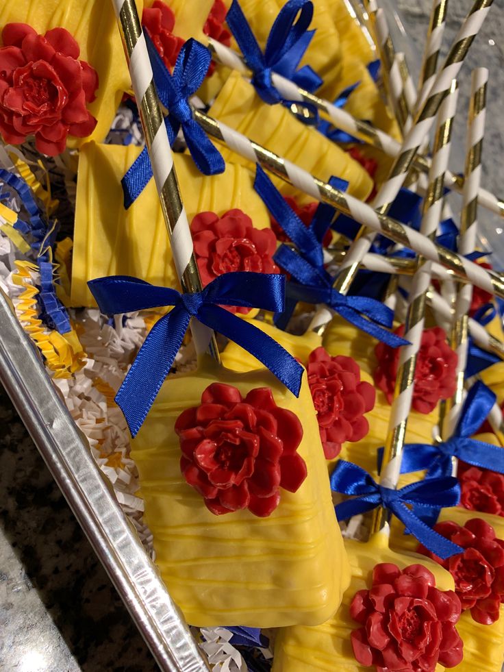 there are many candy shaped like flowers on the table with blue and red streamers