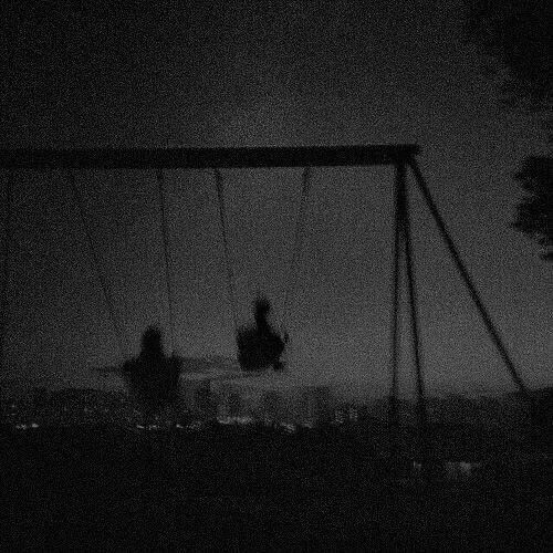 two people sitting on swings in the dark