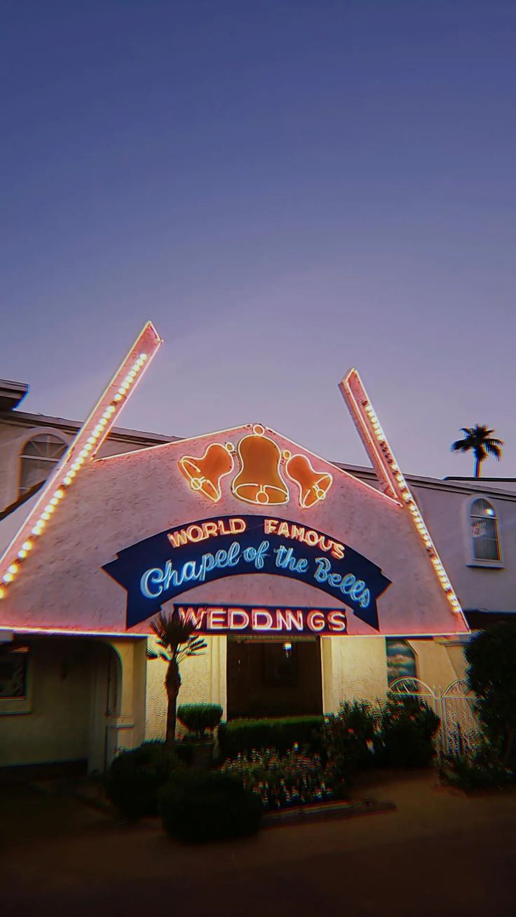 the front of a wedding venue with lights on it's roof and sign that says world famous chapel of the angels