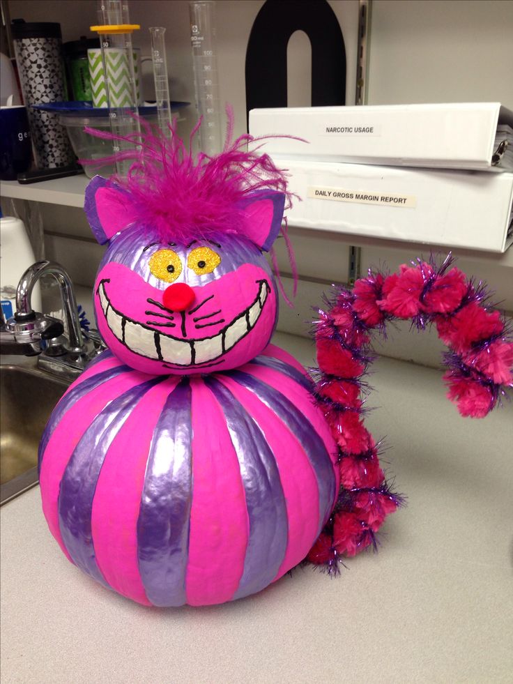 a pink and purple cat decoration sitting on top of a counter next to a sink