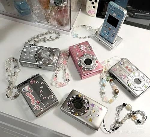 there are many different cameras on the table with necklaces and bracelets around them